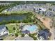 This aerial view showcases a community pool and clubhouse surrounded by homes and a serene lake at 1604 Upper Park Rd, Wake Forest, NC 27587