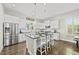 Bright kitchen featuring stainless steel appliances, white cabinets, and a dark island with barstool seating at 1604 Upper Park Rd, Wake Forest, NC 27587