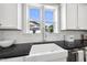 Close-up of bright kitchen featuring white farmhouse sink, subway tile backsplash, and stainless steel appliances at 1604 Upper Park Rd, Wake Forest, NC 27587