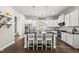 Bright kitchen with stainless steel appliances, white cabinetry, and a dark island with barstool seating at 1604 Upper Park Rd, Wake Forest, NC 27587