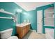 Bathroom with teal walls, and sinks, a large mirror and a door to the shower and bathtub at 1617 Heritage Garden St, Wake Forest, NC 27587