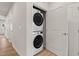 The laundry room has a stacked white washer and dryer, in a room adjacent to a doorway at 1745 Ripley Woods St, Wake Forest, NC 27587