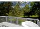 View from the white deck with outdoor seating overlooking a lush, green backyard with mature trees at 1815 Chandellay Dr, Durham, NC 27705