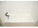 White bathtub with black fixtures and tiled walls at 1815 Chandellay Dr, Durham, NC 27705