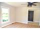Bright bedroom with modern ceiling fan, hardwood flooring, and view of backyard trees at 1815 Chandellay Dr, Durham, NC 27705