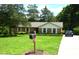 Inviting brick home with tidy landscaping, mailbox, and a paved driveway leading to a car at 1815 Chandellay Dr, Durham, NC 27705