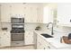 Modern kitchen featuring white cabinets, stainless steel appliances, and black hardware at 1815 Chandellay Dr, Durham, NC 27705