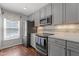 Modern kitchen with stainless steel appliances, gray cabinets, and hardwood floors at 1815 Crystal Downs Lane, Raleigh, NC 27604