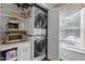 Efficient laundry closet with stacked washer and dryer, shelving, and cabinets for organization at 1815 Crystal Downs Lane, Raleigh, NC 27604