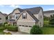 Two-story home featuring beige siding, black shutters, and an attached garage at 184 Elgin Ct, Burlington, NC 27215