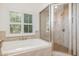 A modern bathroom with a tub and glass-enclosed shower at 20002 Fountain, Chapel Hill, NC 27517
