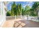 Exterior wooden deck with a white railing surrounded by greenery at 20002 Fountain, Chapel Hill, NC 27517