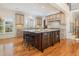 Well-lit kitchen features a large island with seating and granite countertops plus custom cabinetry at 20002 Fountain, Chapel Hill, NC 27517