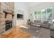 Cozy living room features stone fireplace, built-in shelving, and a large window, furnished with comfortable seating at 20002 Fountain, Chapel Hill, NC 27517
