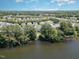 Wide aerial view of a community of homes situated along a lake, surrounded by lush trees at 2053 Thornblade Dr, Raleigh, NC 27604