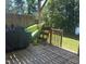 Wooden back deck with barbecue grill and kayak, overlooks lawn and lake at 2053 Thornblade Dr, Raleigh, NC 27604