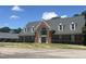 Charming brick home featuring dormer windows and mature landscaping at 2053 Thornblade Dr, Raleigh, NC 27604