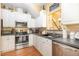 Well-equipped kitchen with stainless steel appliances, white cabinets, and a functional layout at 2053 Thornblade Dr, Raleigh, NC 27604