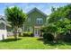 Large backyard showcasing well-kept lawn, mature trees, and the exterior of the home at 2112 Dunn Rd, Raleigh, NC 27614