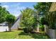 Backyard with green grass, a stone path, mature landscaping and home exterior at 2112 Dunn Rd, Raleigh, NC 27614