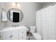 Bathroom features white vanity, round mirror, toilet, and shower at 2112 Dunn Rd, Raleigh, NC 27614