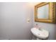 Small bathroom with pedestal sink and decorative mirror at 2112 Dunn Rd, Raleigh, NC 27614