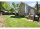 Lawn area and wooden deck of backyard featuring stone stairway and landscaping at 217 Dalmeny Dr, Cary, NC 27513