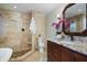 Well-lit bathroom with a beautiful tiled shower, soaking tub, granite countertop, and wood cabinetry at 217 Dalmeny Dr, Cary, NC 27513