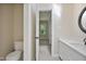 Clean bathroom with white cabinets, toilet and sink vanity, as well as open doorway to bedroom at 217 Dalmeny Dr, Cary, NC 27513