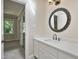 Bathroom vanity with round mirror and view of the bedroom through an open doorway at 217 Dalmeny Dr, Cary, NC 27513