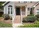 Close-up of the inviting front entrance with brick steps and manicured shrubbery at 217 Dalmeny Dr, Cary, NC 27513