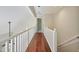 Upstairs hallway with hardwood floors and white railing offers a bright and open feel at 217 Dalmeny Dr, Cary, NC 27513