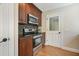 Kitchen with modern stainless steel appliances, dark cabinetry, and wood floors at 217 Dalmeny Dr, Cary, NC 27513
