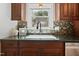 Charming kitchen sink with dark granite countertops, mosaic backsplash, and warm wood cabinetry at 217 Dalmeny Dr, Cary, NC 27513