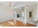 Open living room with fireplace and hardwood floors leading to carpeted den at 217 Dalmeny Dr, Cary, NC 27513