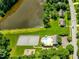 Aerial view featuring a pool, tennis court, lake, and homes in a community at 221 Antique Lace Way, Holly Springs, NC 27540