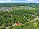 This aerial view shows homes surrounded by mature trees near Bass Lake and Sugg Farm at 221 Antique Lace Way, Holly Springs, NC 27540