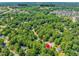 An aerial view showcases homes nestled among mature trees near Womble Park and the hospital at 221 Antique Lace Way, Holly Springs, NC 27540