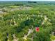 Expansive aerial view of a neighborhood with a red pin, surrounded by lush green trees at 221 Antique Lace Way, Holly Springs, NC 27540