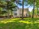 Lush backyard showcasing mature trees, wooden fence, and a deck area with outdoor furniture at 221 Antique Lace Way, Holly Springs, NC 27540
