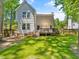 Spacious backyard showcasing a deck, green lawn, mature trees and a wooden fence at 221 Antique Lace Way, Holly Springs, NC 27540