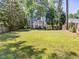 Expansive backyard featuring well-maintained lawn, mature trees and a wooden fence at 221 Antique Lace Way, Holly Springs, NC 27540