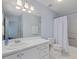 Clean bathroom featuring a white vanity, large mirror, and combined tub/shower at 221 Antique Lace Way, Holly Springs, NC 27540