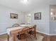 Charming dining room with wooden table and chairs, decorative wainscoting, and views to the exterior at 221 Antique Lace Way, Holly Springs, NC 27540