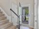 Inviting entryway featuring a staircase with carpeted steps and a view through the storm door to the outdoors at 221 Antique Lace Way, Holly Springs, NC 27540
