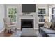 Cozy living room showcasing a fireplace, TV, neutral furniture, and natural light from surrounding windows at 221 Antique Lace Way, Holly Springs, NC 27540