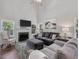 Spacious living room featuring a fireplace, large windows, plush seating, and a ceiling fan at 221 Antique Lace Way, Holly Springs, NC 27540