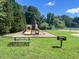 Community playground featuring slides, swings, picnic table and grill for outdoor fun at 221 Antique Lace Way, Holly Springs, NC 27540