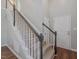 Inviting staircase with neutral carpet and painted railings, leading to the upper level at 221 Antique Lace Way, Holly Springs, NC 27540