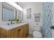Bathroom with double vanity, blue accents, and a separate toilet at 2317 Bertie Dr, Raleigh, NC 27610